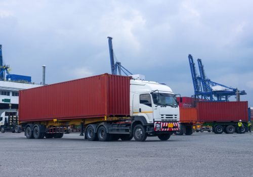 Container red truck in ship port Logistics.Transportation industry in port business concept.import,export logistic industrial Transporting Land transport freight warehouse storge